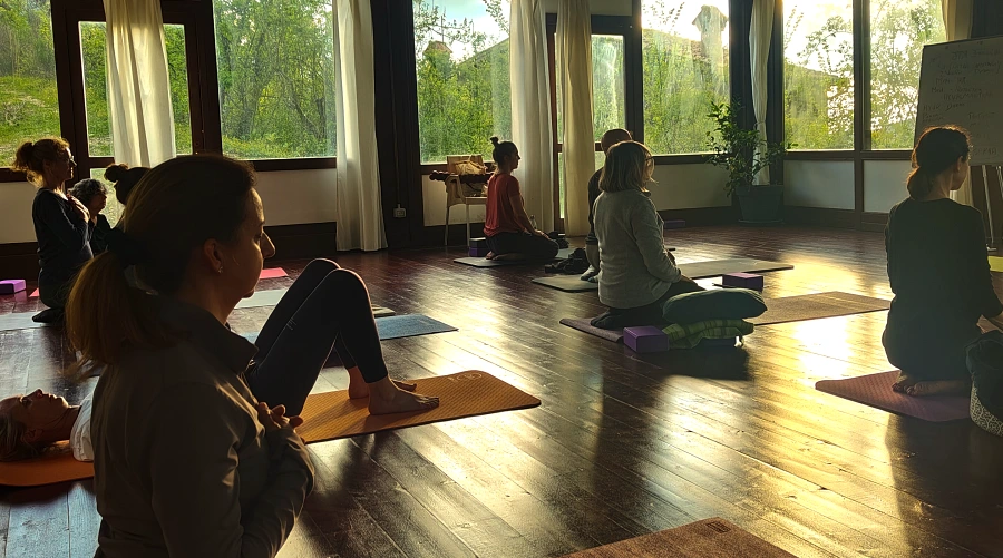 Morning yoga session in the sunlit wooden shala at Prana Retreat Italy